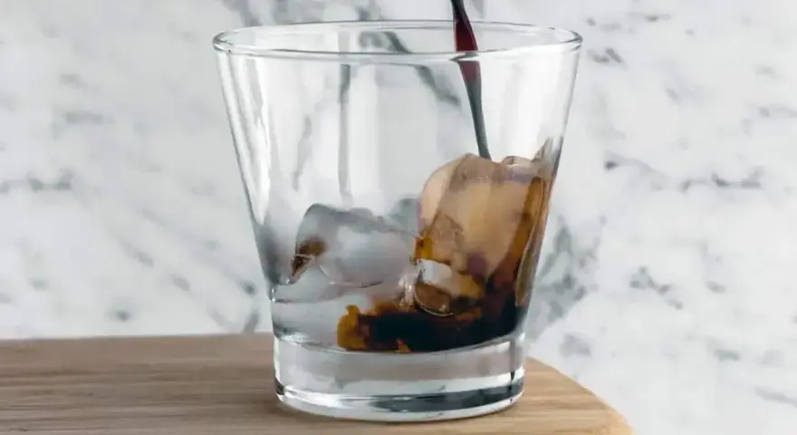 Kall kaffedrink hälls i ett glas med is.