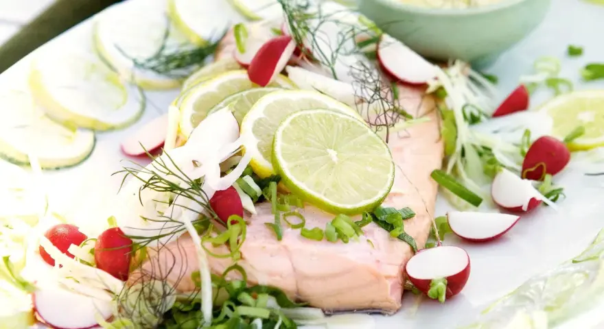 En vacker bit inkokt lax serverad med citronskivor, rädisor, fänkål och dill. En fräsch och somrig rätt.