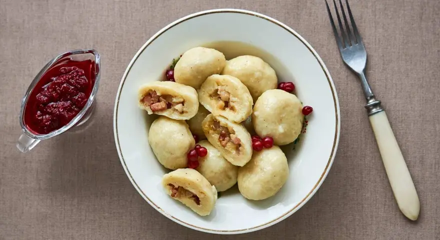En skål med kroppkakor, en klassisk svensk rätt, serveras med lingonsylt. Recept på kroppkakor finns här.