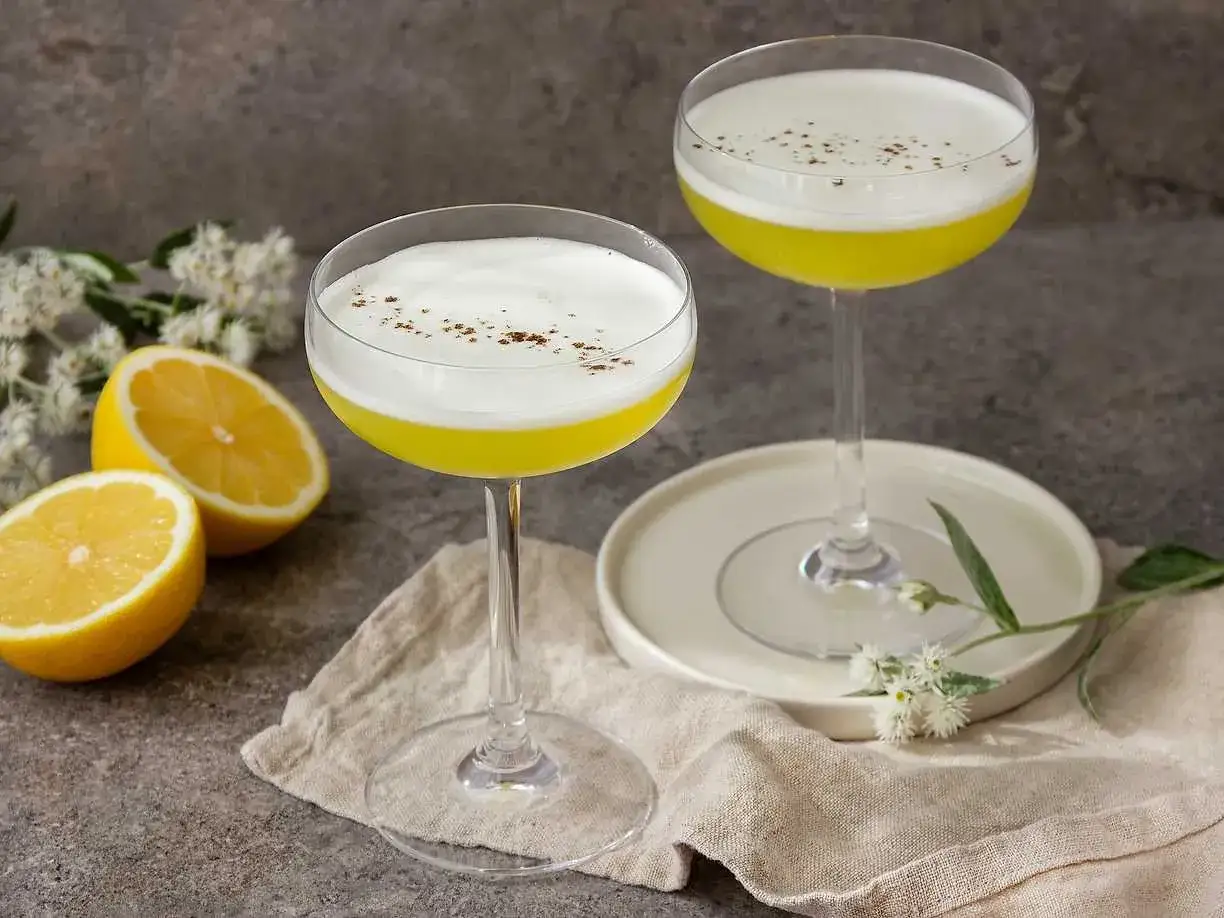 Två eleganta drinkar med citronsmak och fluffigt skum, garnerade med kanel. Perfekt för ett sockerlag recept.