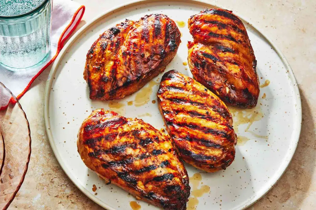 Fyra saftiga kycklingfiléer med grillränder, perfekt marinerade för en somrig grillkväll.