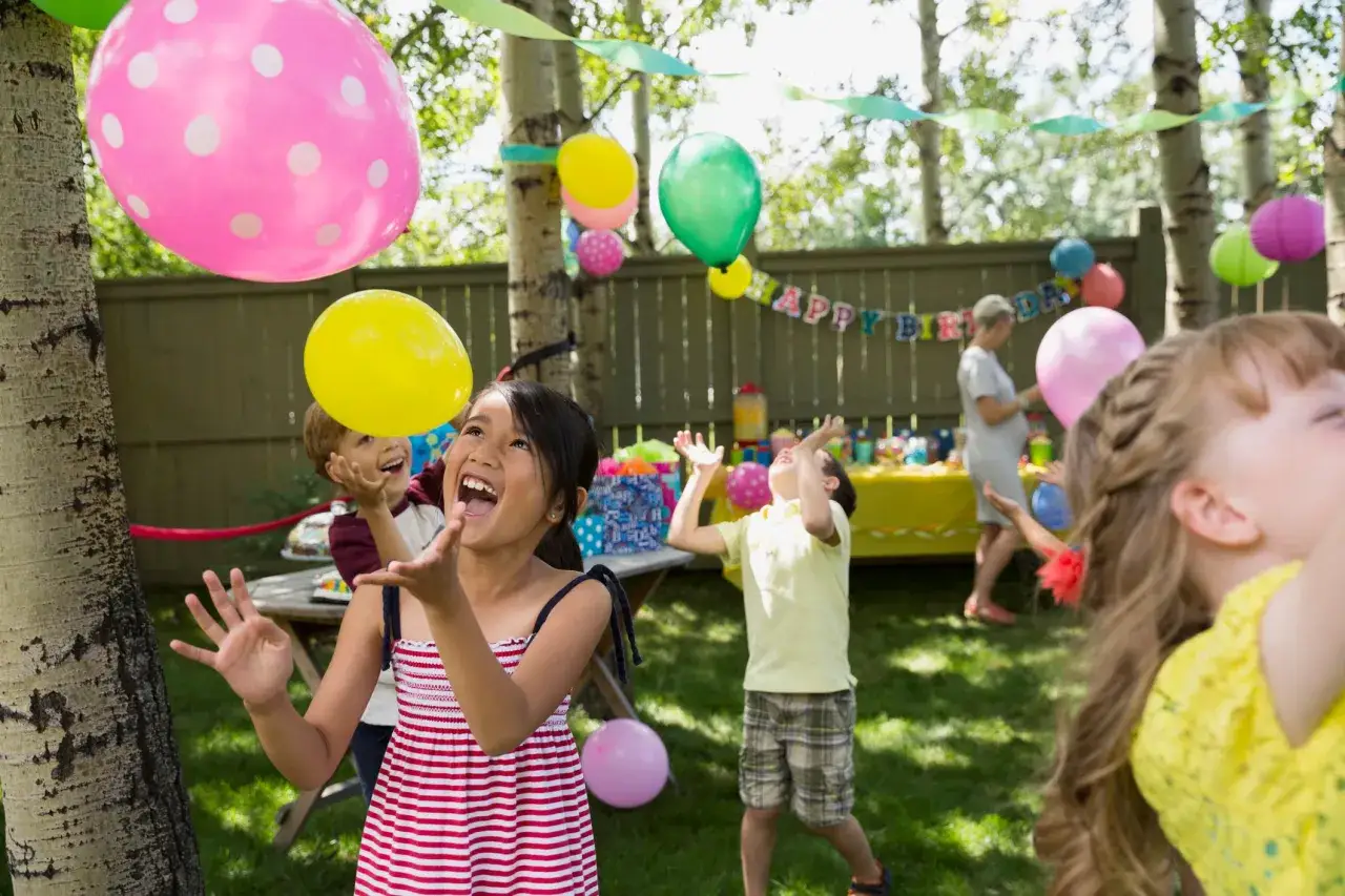 Glada barn kastar upp ballonger p&aring; ett barnkalas. Perfekt f&ouml;r barnkalas lekar 6 &aring;r.