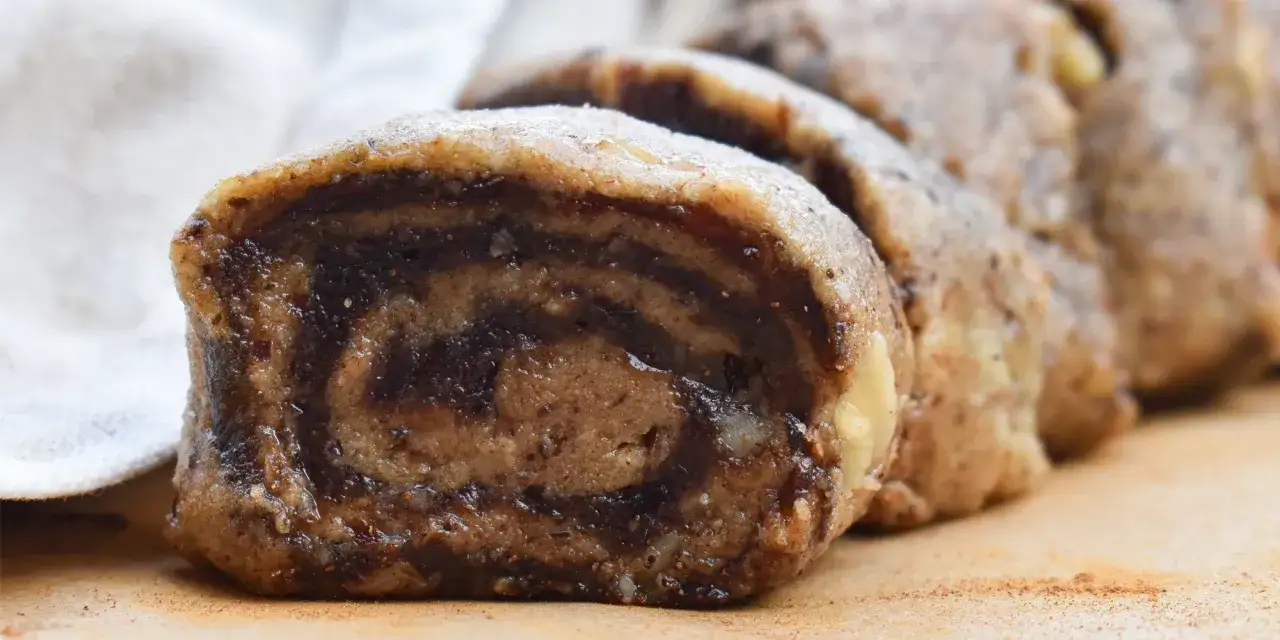 Närbild på nyttiga kanelbullar med mörk fyllning och ljus deg, skurna i skivor.