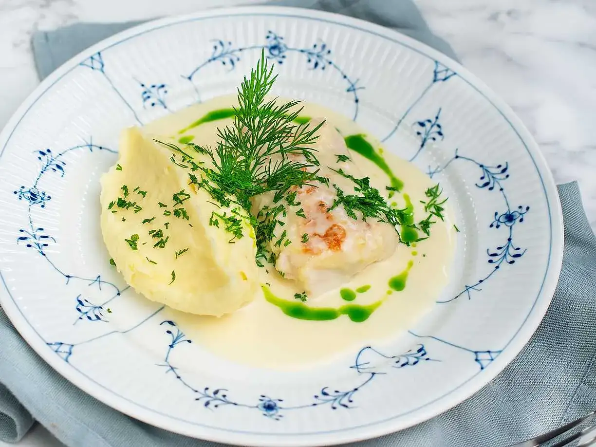 En portion torskrygg i ugn serveras med krämigt potatismos, en len sås och dill.