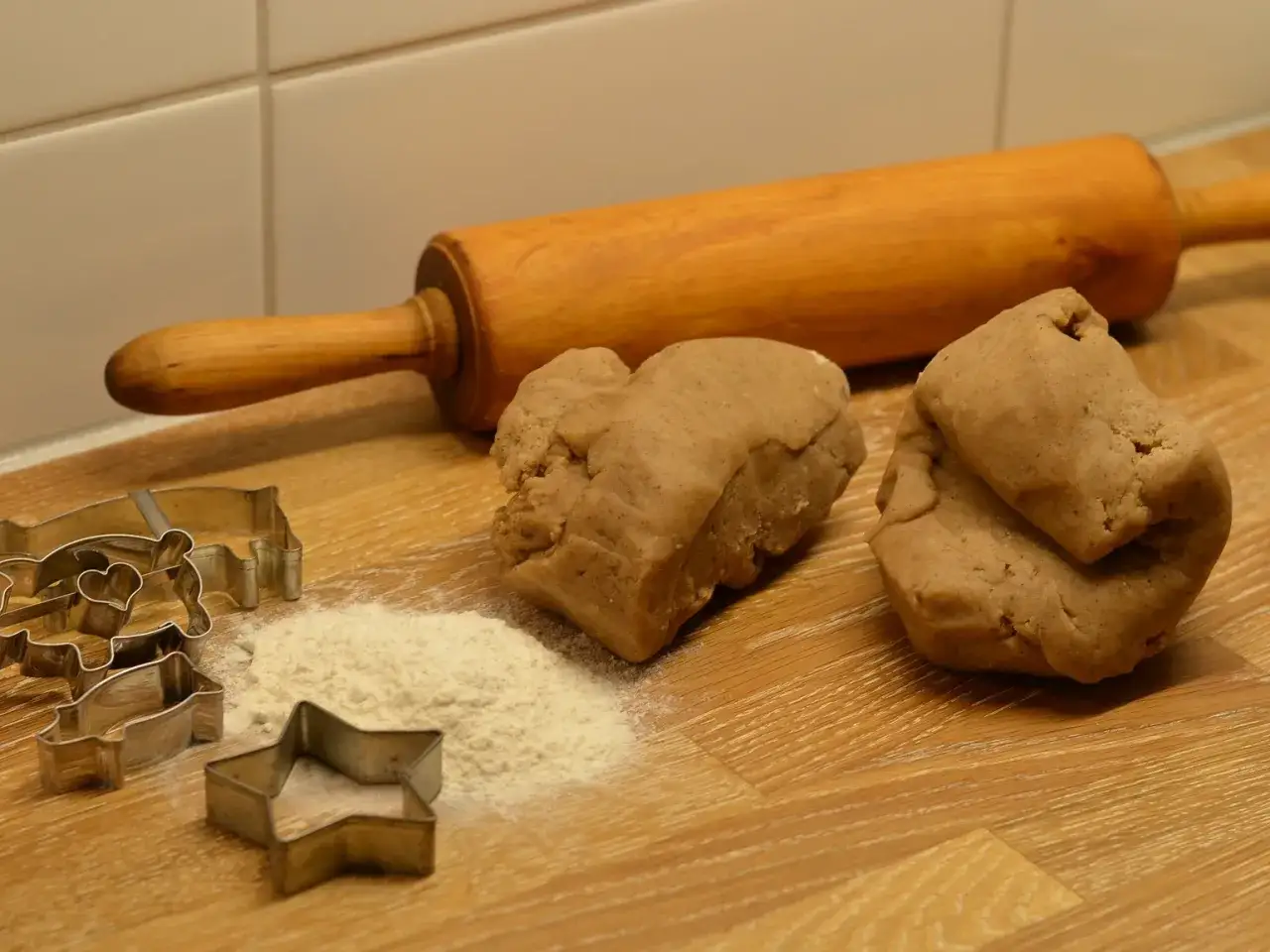 Pepparkaksdeg recept redo för utbakning med pepparkaksformar, kavel och mjöl.