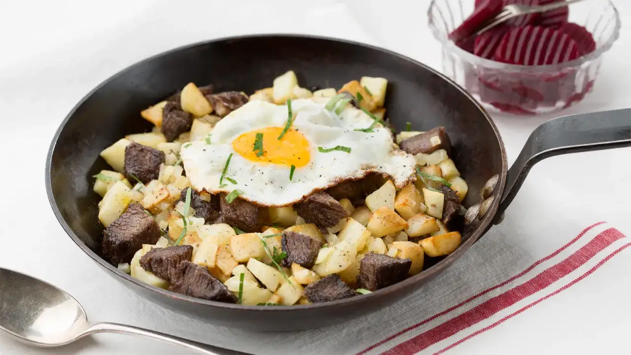 En klassisk pytt i panna med stekt &auml;gg, k&ouml;tt och potatis i en gjutj&auml;rnspanna. Serveras med inlagda r&ouml;dbetor.