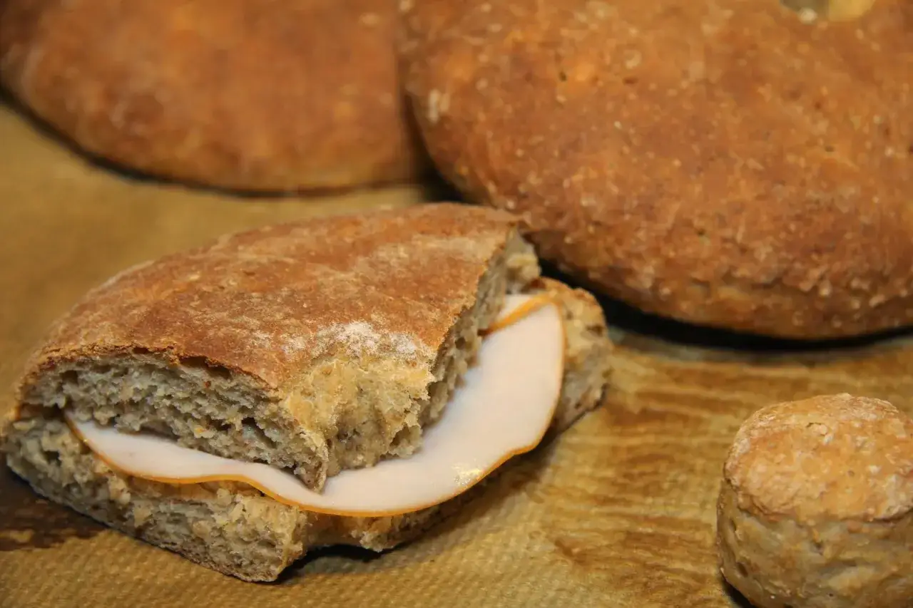 Här är ett enkelt rågkakor recept: en halverad rågkaka med skinka och en hel rågkaka i bakgrunden.