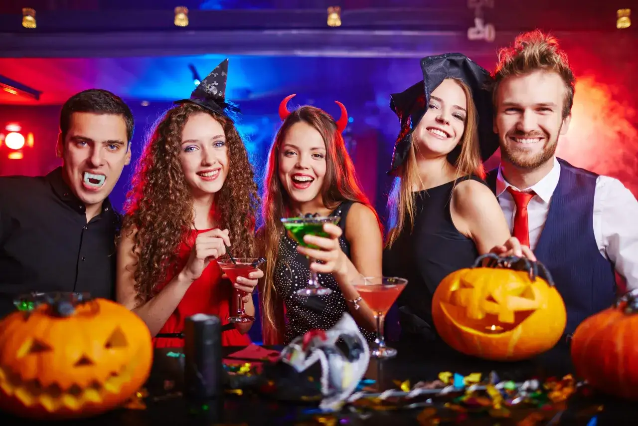 Glada vuxna firar halloween med drinkar och pumpor. En vampyr, en h&auml;xa och en dj&auml;vul njuter av festen. Perfekt f&ouml;r halloween lekar vuxna!