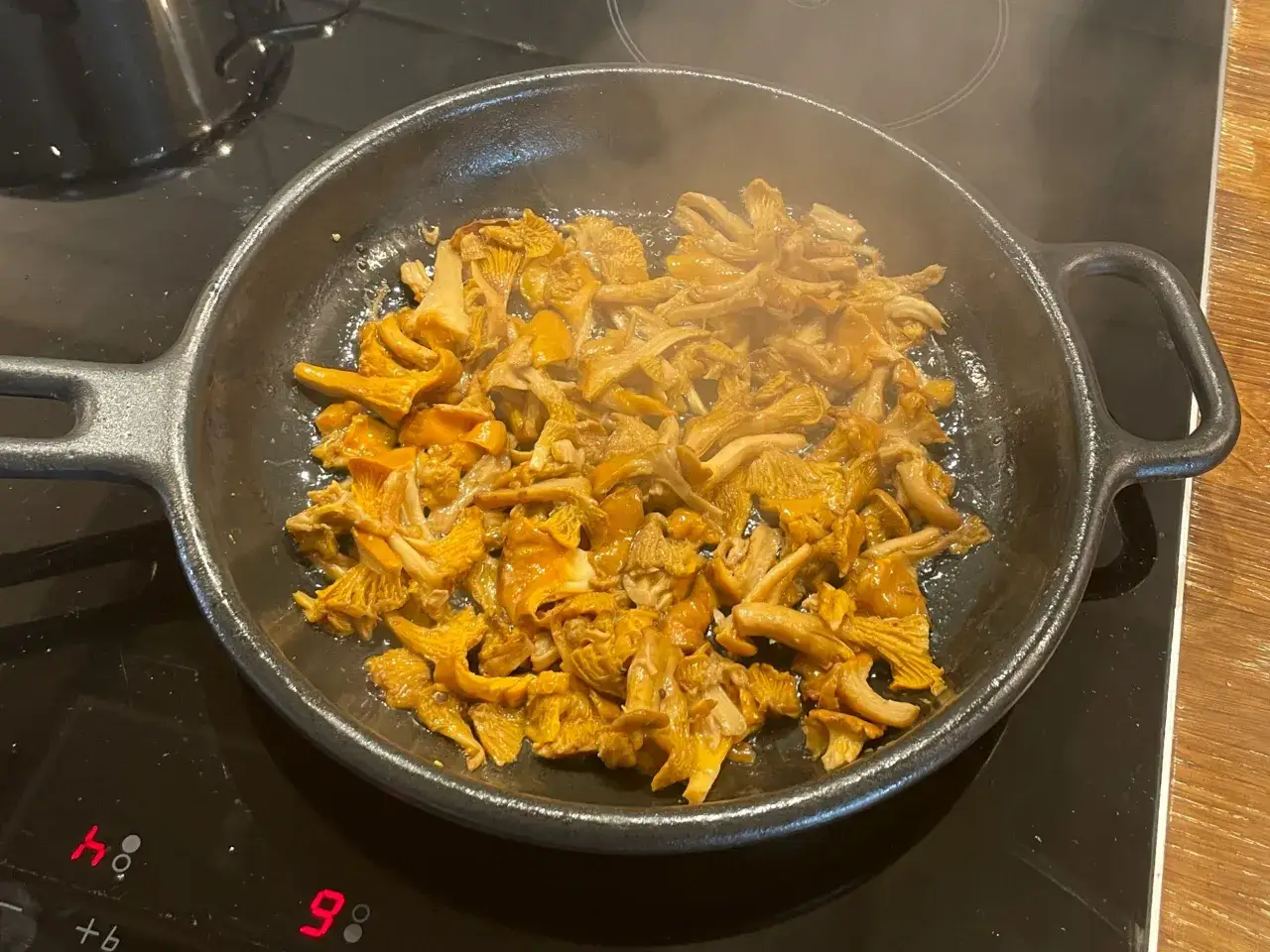 Gyllene kantareller fräser i en gjutjärnspanna på spisen. Doften sprider sig i köket, snart är det dags att njuta av dessa smörstekta delikatesser.