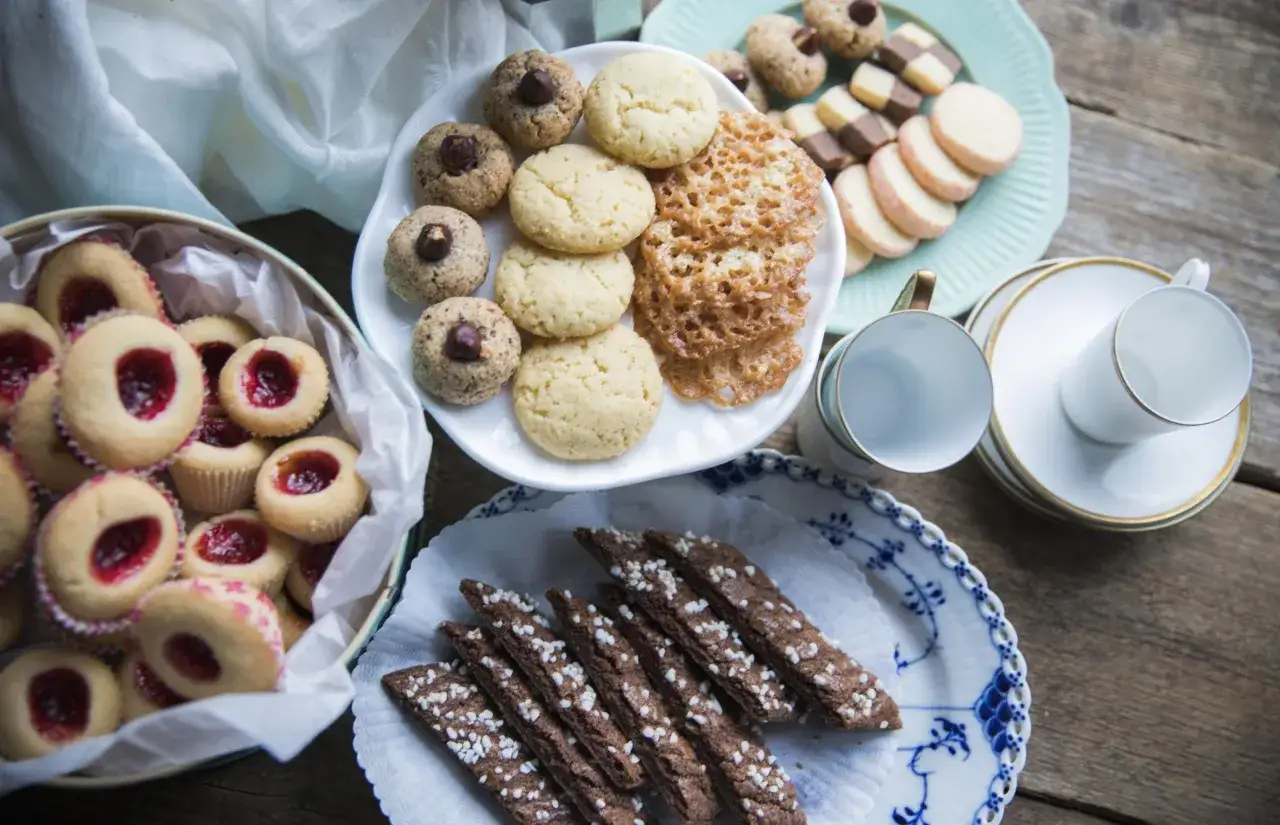 En härlig uppdukning med sju sorters kakor recept, inklusive syltkakor, nötkakor och chokladkakor, redo att avnjutas.